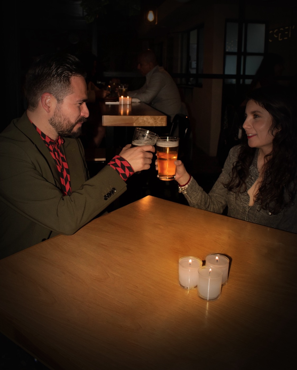 Una pareja brinda con cerveza a la luz de las velas