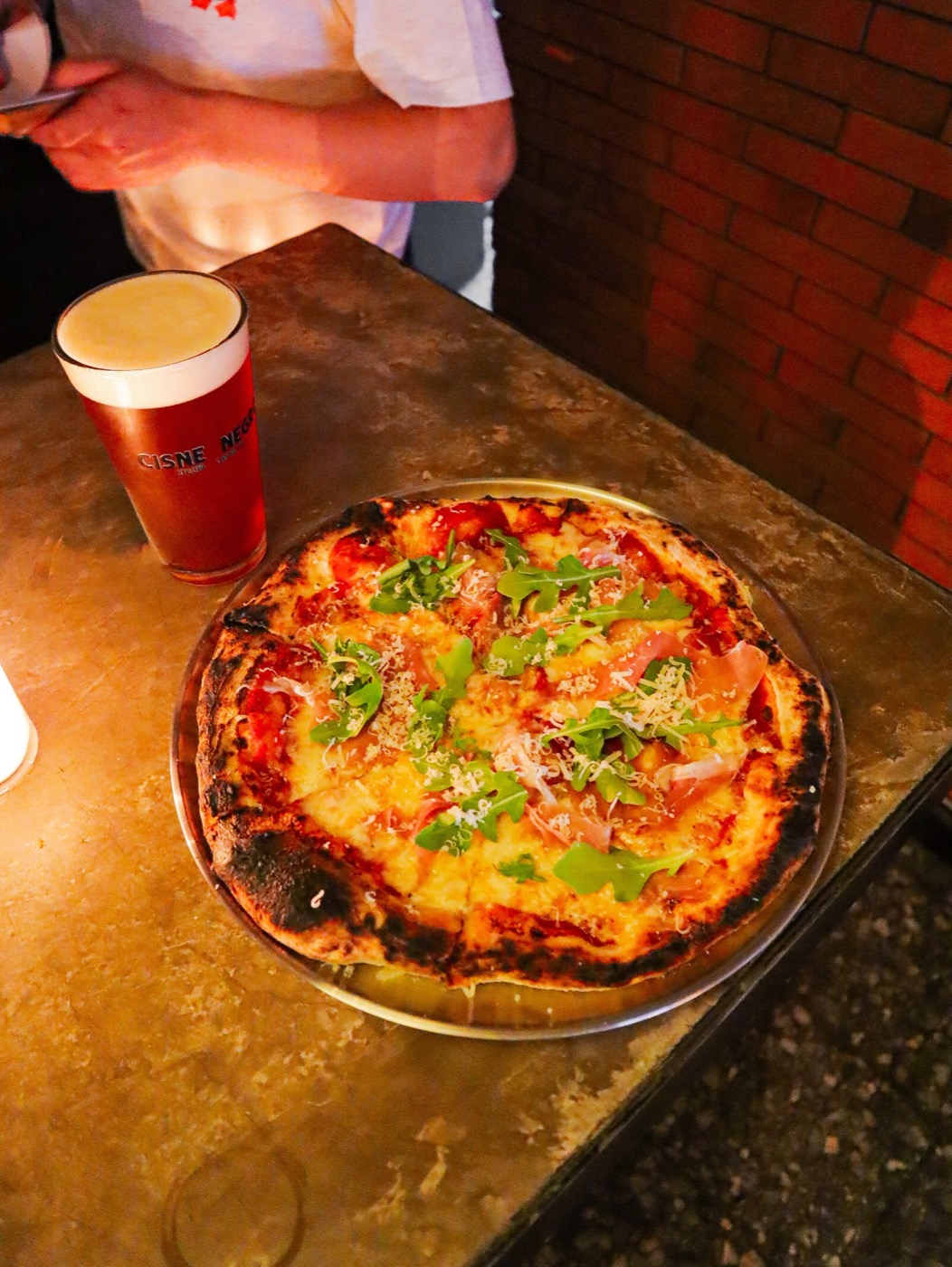 Pizza artesanal y una pinta de cerveza sobre la barra en la Noche de Velas y Pizza